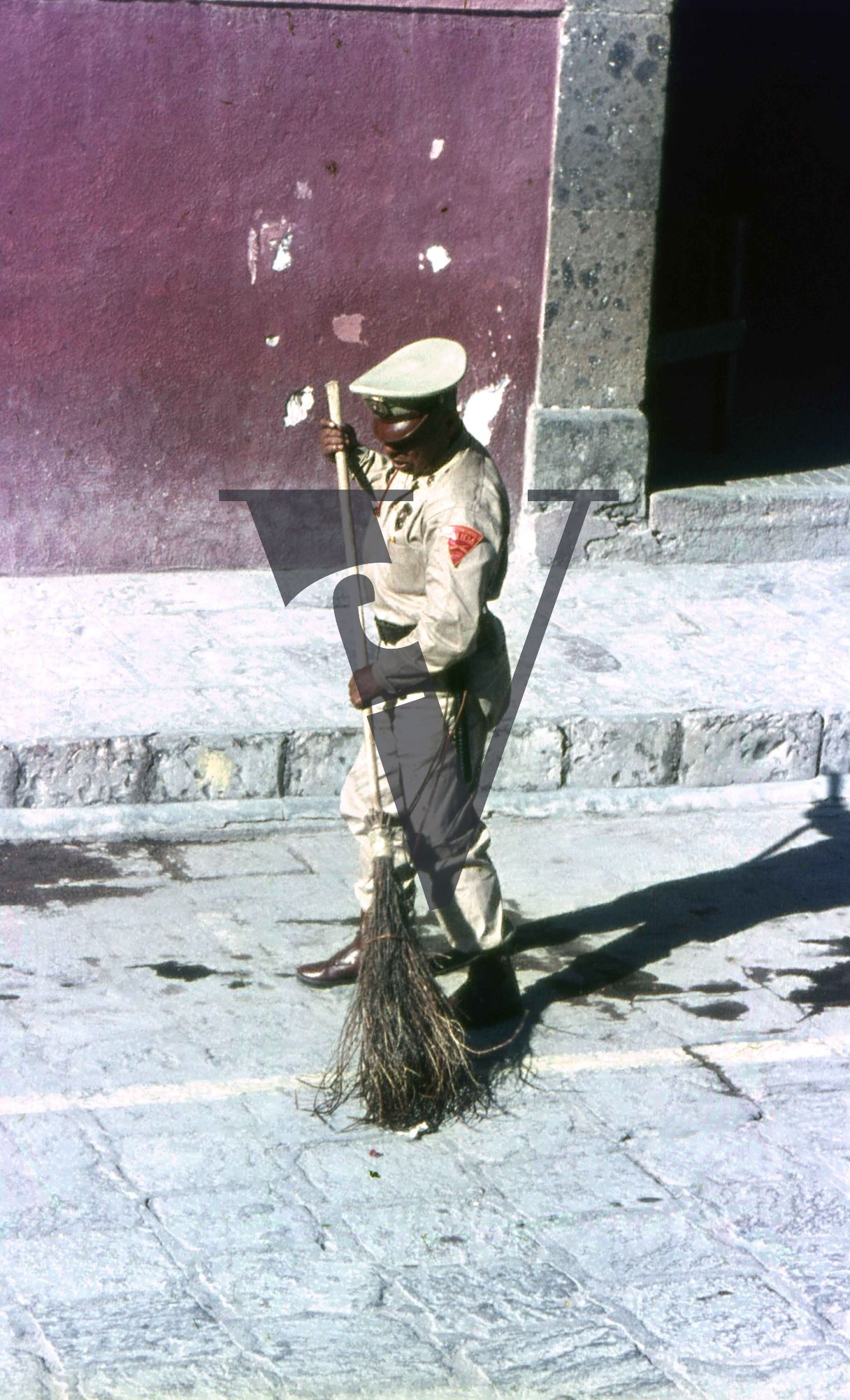 Mexico, Man in uniform sweeps streets.