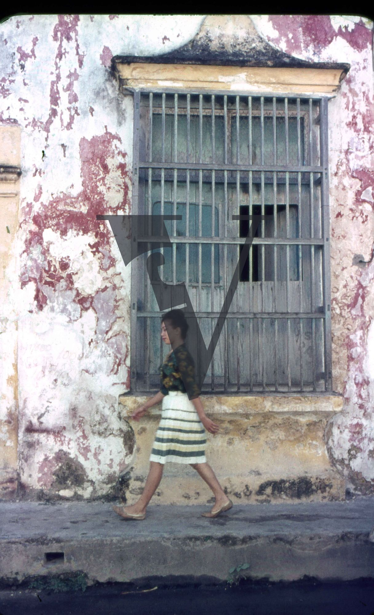 Mexico, Woman walks past window.