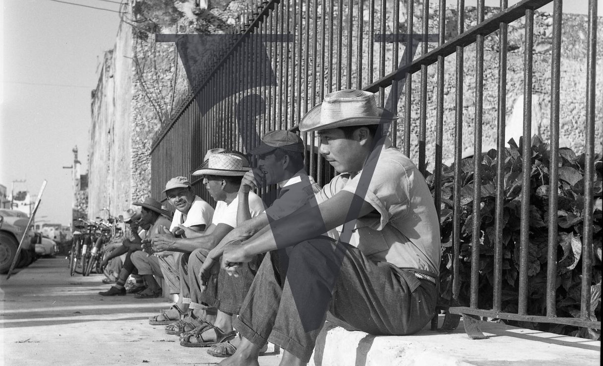 Mexico, Men in hats line up on pavement.