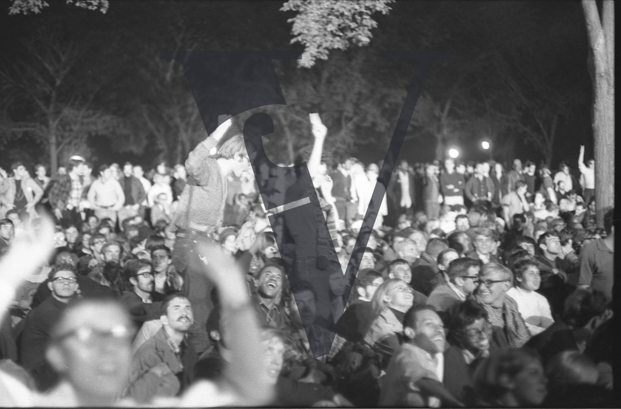 Chicago, Anti-war rallies in Lincoln Park, cheering crowd, park, night-time.