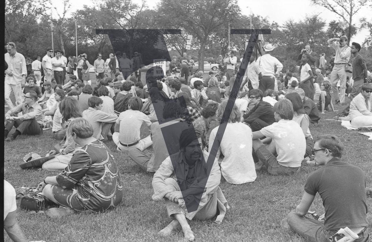 Chicago, Anti-war rallies in Lincoln Park, group of hippy youth sit crossed-leg, sign reads Cease Fire Now.
