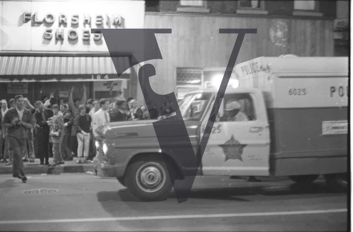 Chicago, Anti-war rallies in Lincoln Park, protestors gather outside a Florsheim Shoes store, police van.