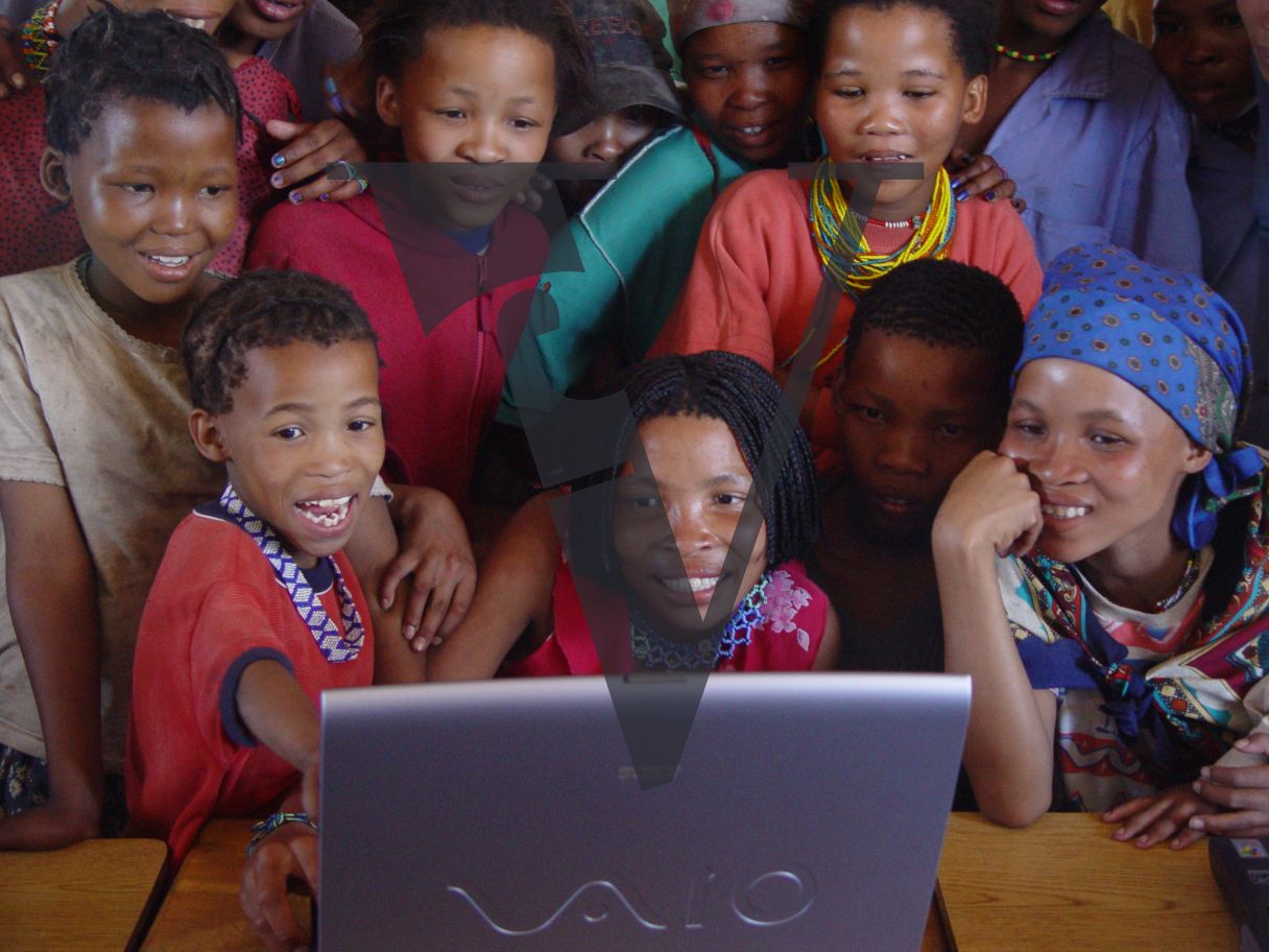 N!Xau, the “Bushman”, family watching film on laptop.