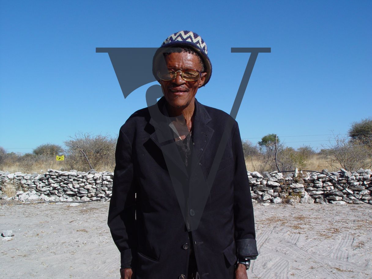 N!Xau, the “Bushman”, portrait, smiling, glasses.