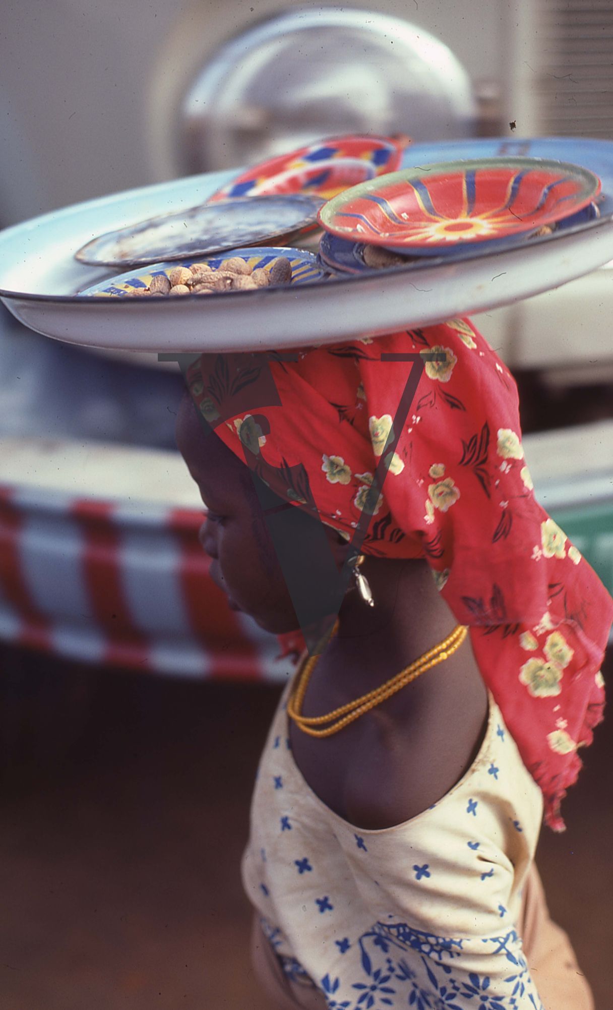Nigeria, young girl with trays on head.