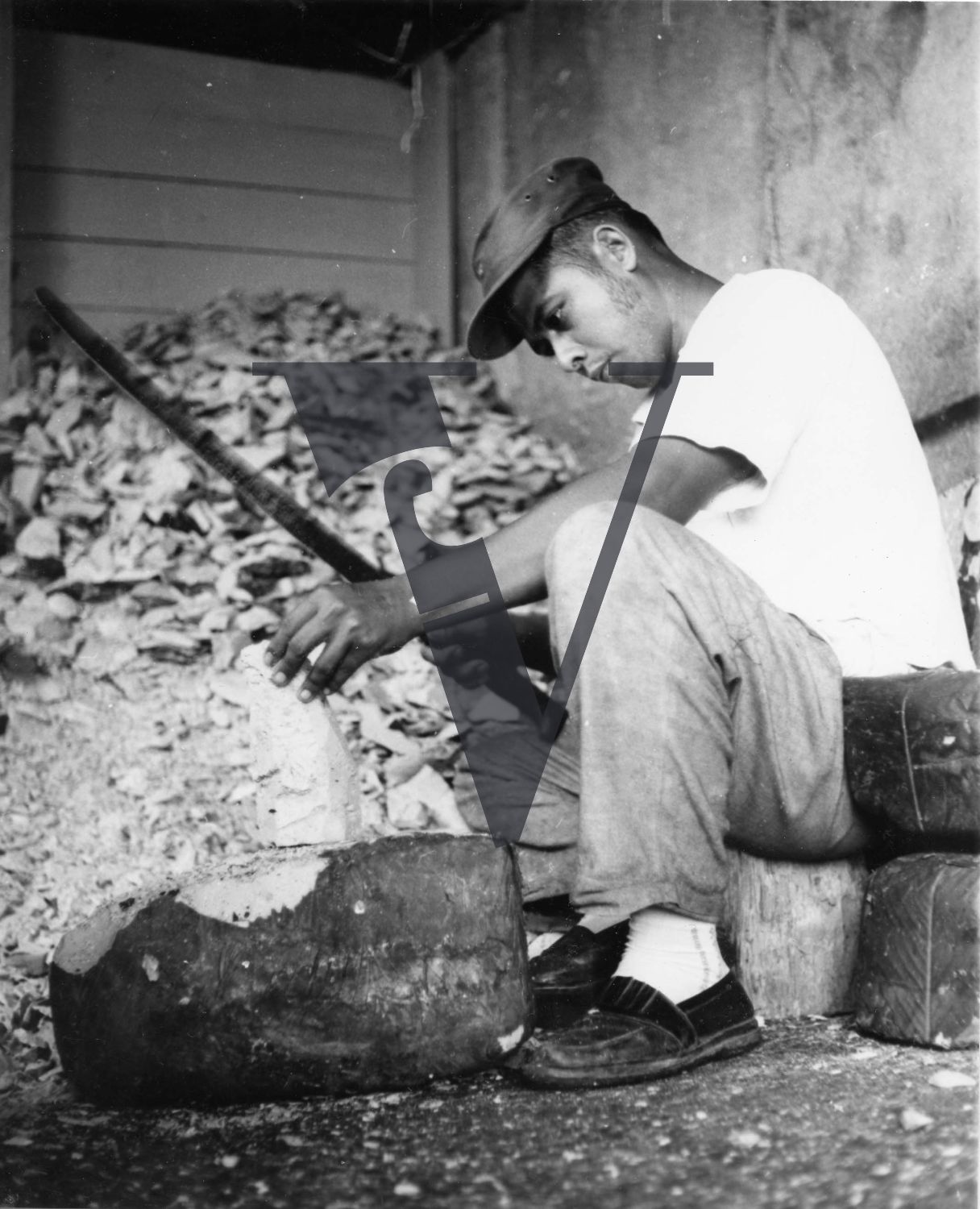 Belize, man cutting wood.