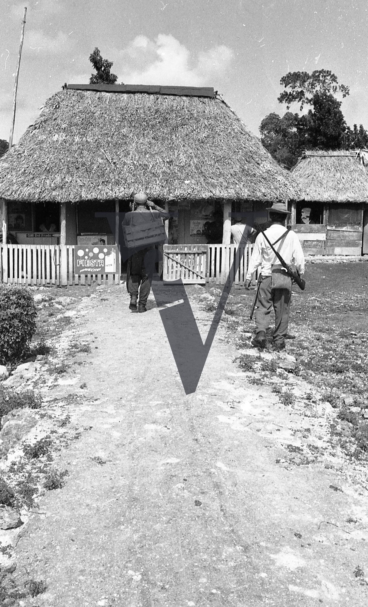 Belize, people walk towards straw shop, advertisement for FIESTA cigarettes.