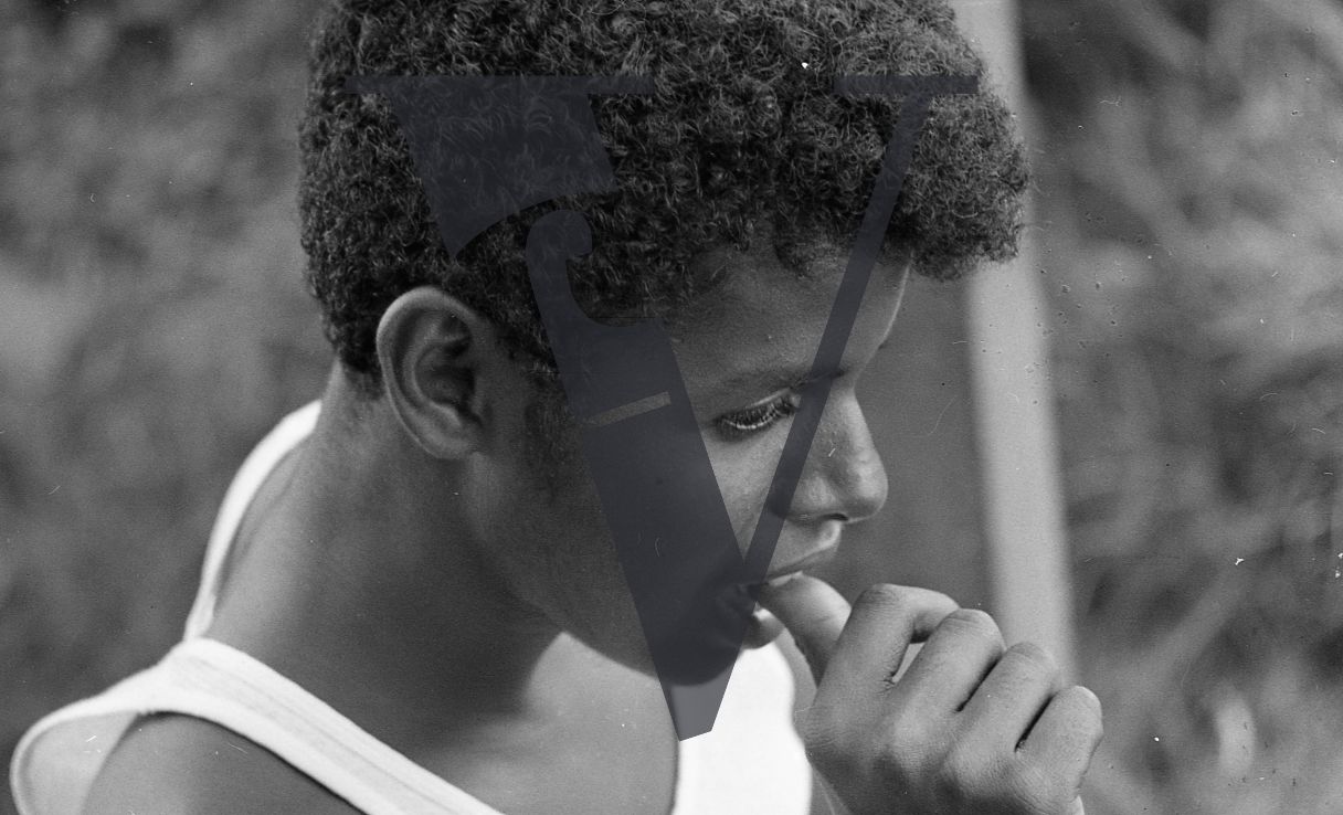 Belize, Portrait, close-up, young man chews fingernails.