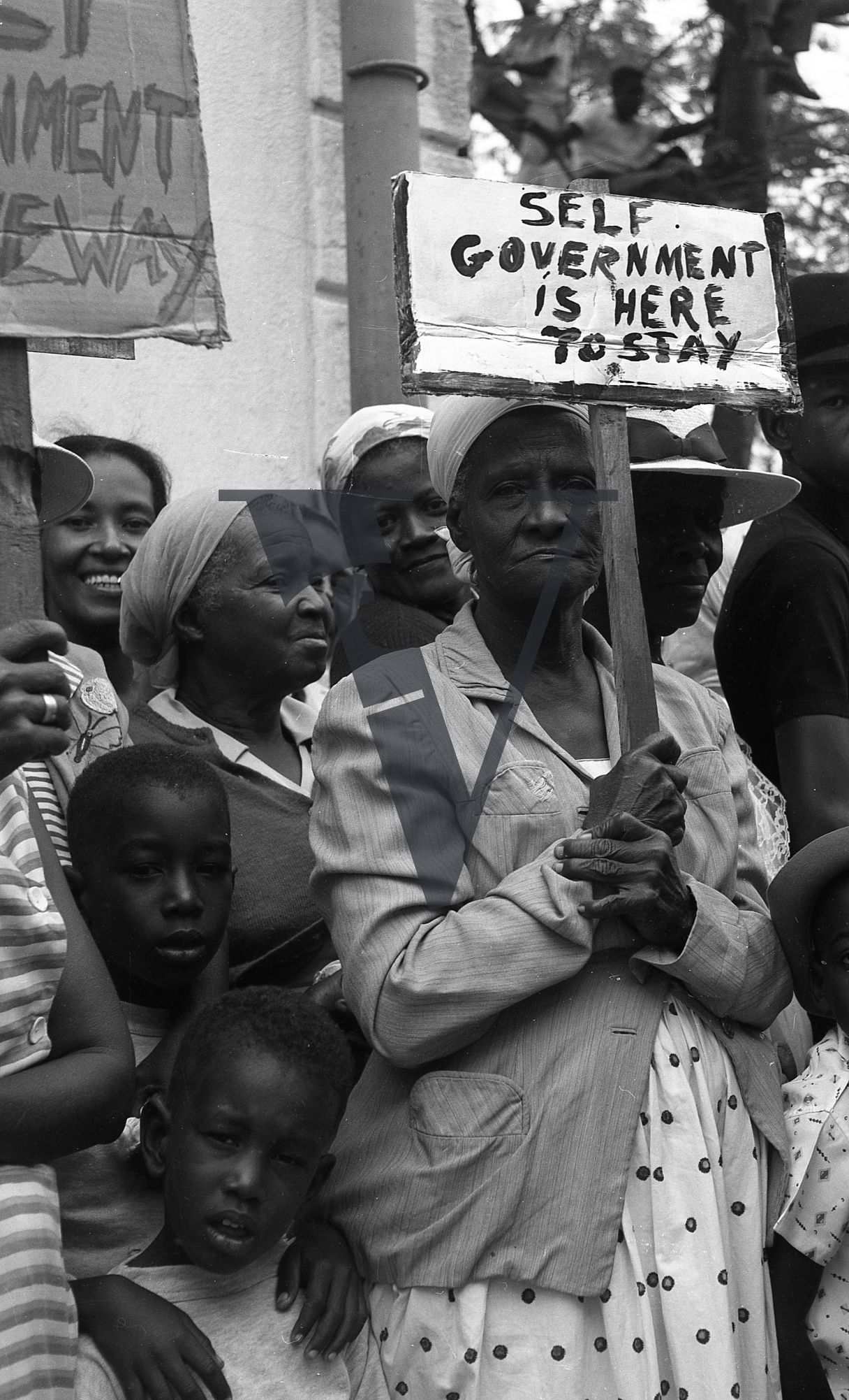 Belize, Political Demonstration, woman holds up 'Self Government Is Here To Stay' sign.