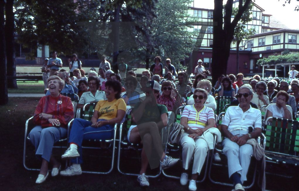 Brickman Hotel, lawn, seated audience, laughing, wide shot.