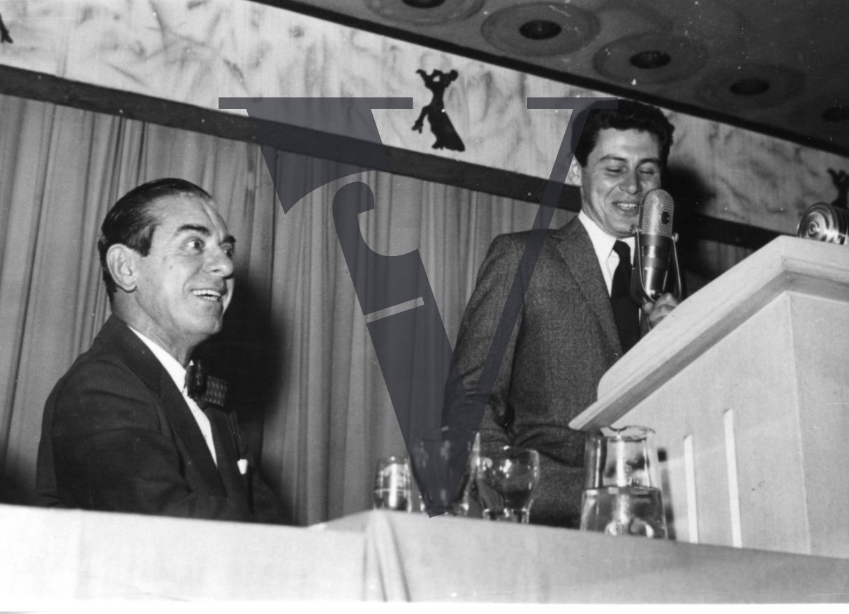 Eddie Fisher and Eddie Cantor, on stage, lecturn, smiling.
