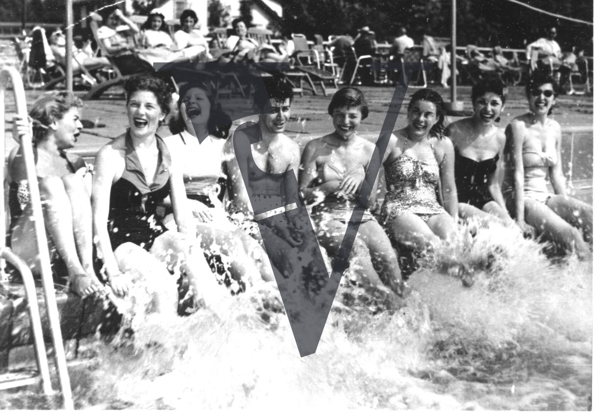 Eddie Fisher with female bathers, “bathing beauties”, “bathing belles”, hotel pool, splashing, wide shot.