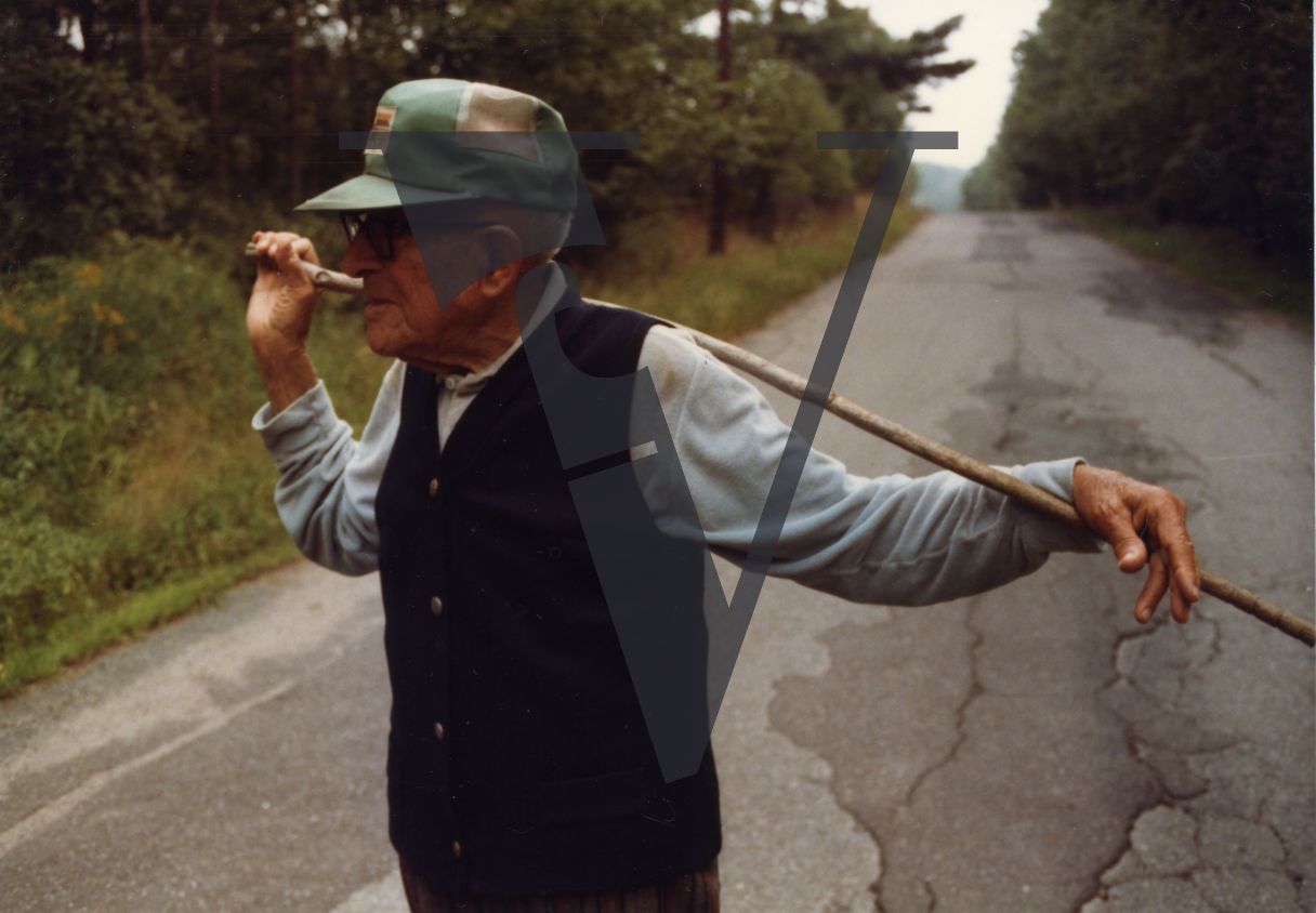 Old man in a cap, country road.