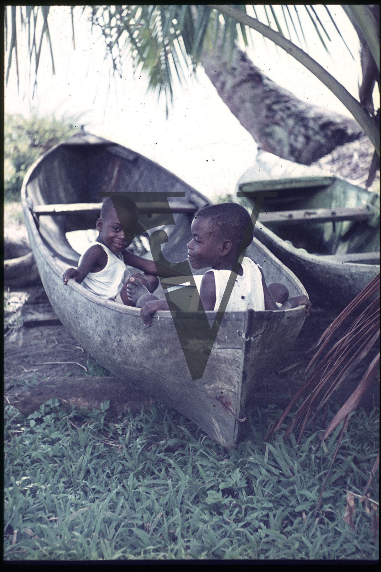 Belize, Ambergris, Two boys sat in boat, smiling.