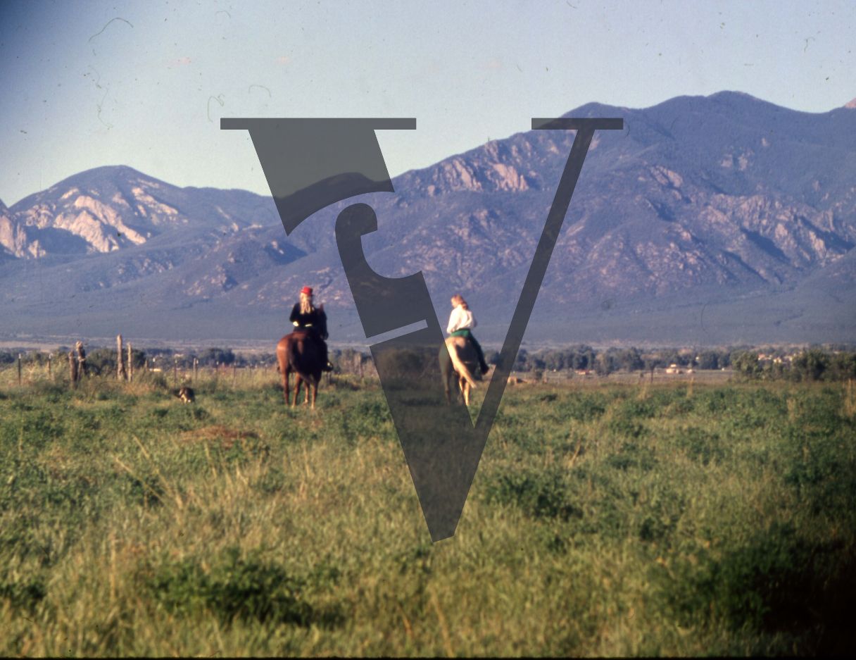 Taos, New Mexico, women on horseback, mountains.