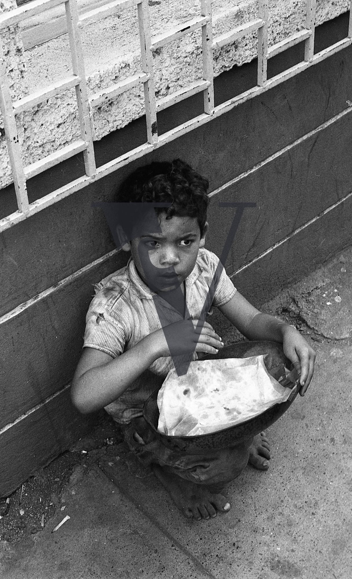 Dominican Republic, boy, portrait, sits crouched.