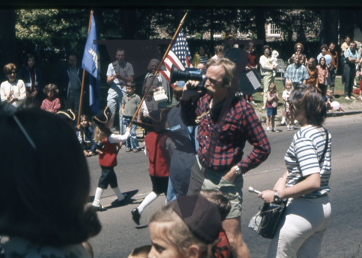 Robert Elfstrom, with camera, 4th Of July parade, flags.