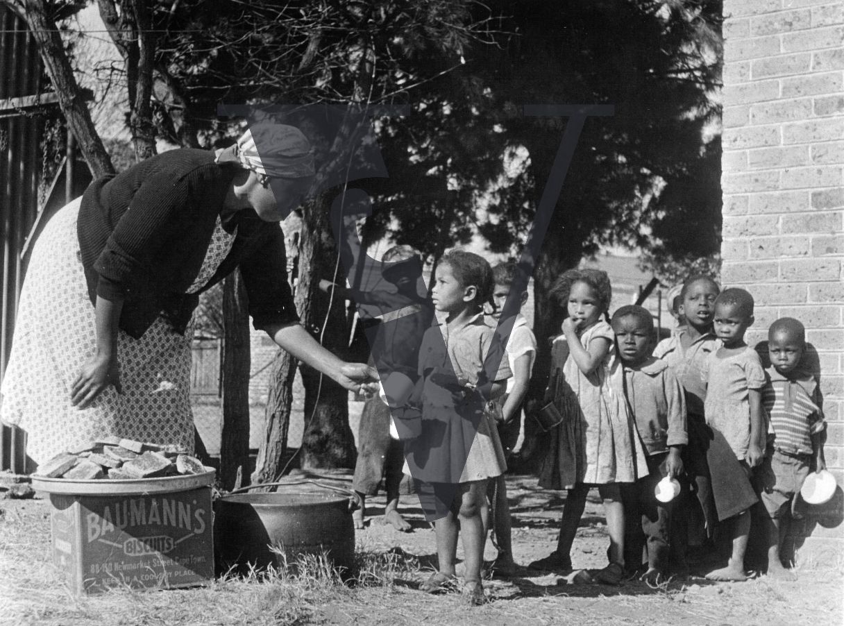 Sophiatown, woman hands out food to children, on a Bauman's Biscuit box.