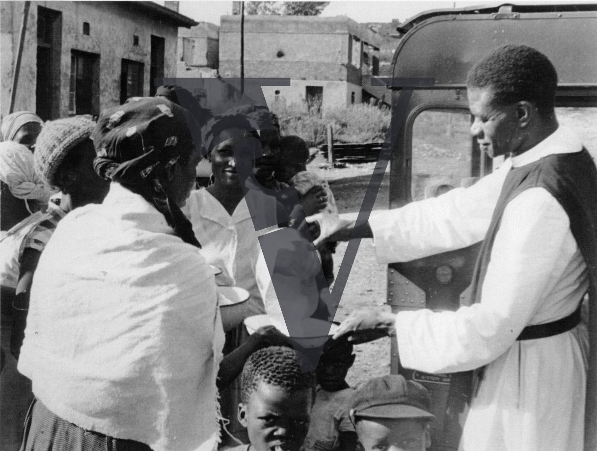 Sophiatown, Father Leo Rakale giving out supplies.