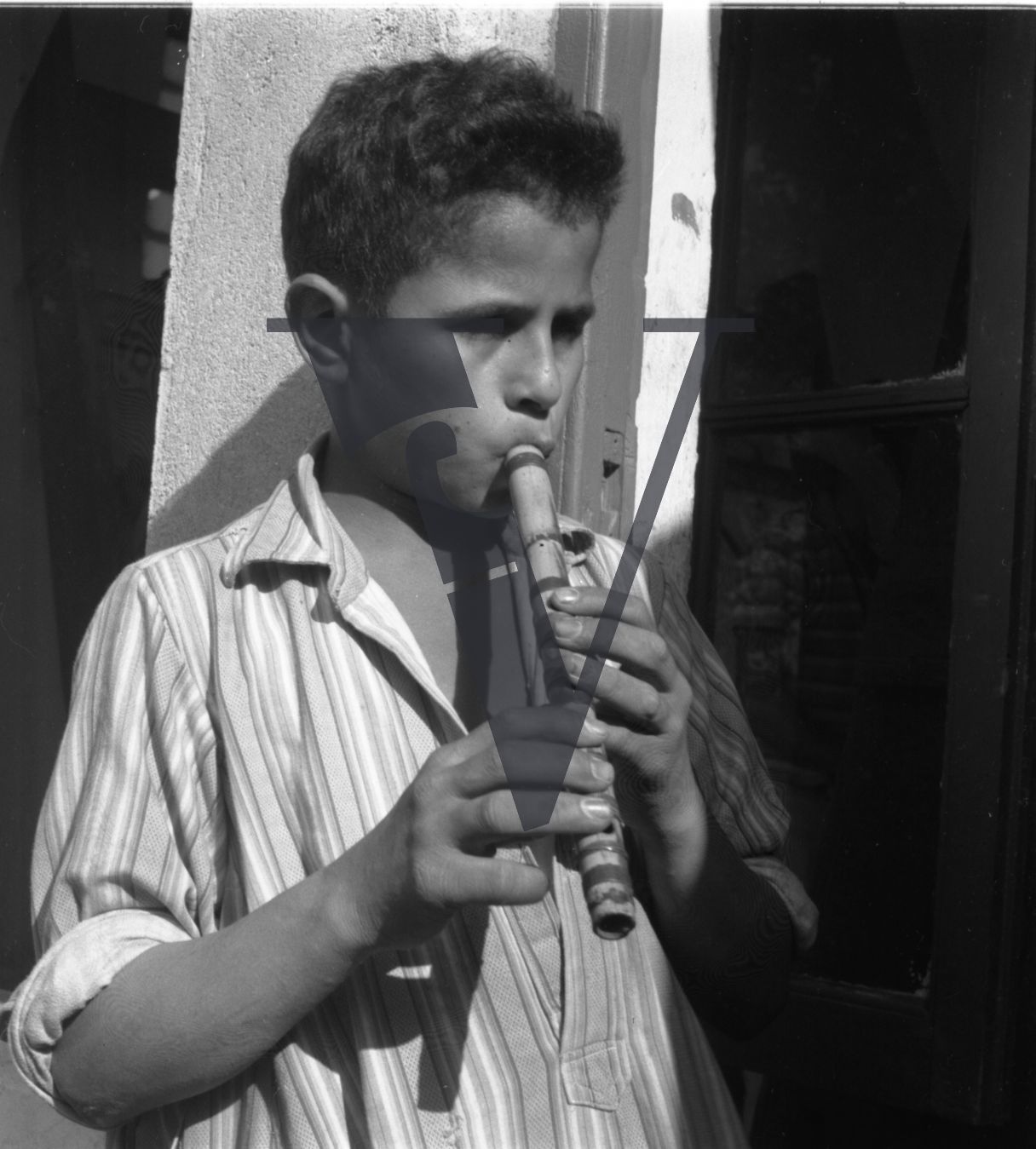 Harrania, Egypt, boy playing flute.