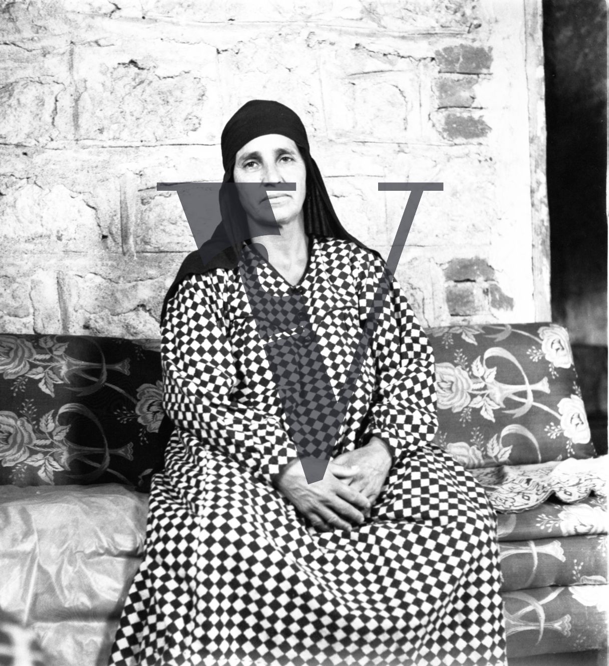 Harrania, Egypt, woman in check dress poses for camera.