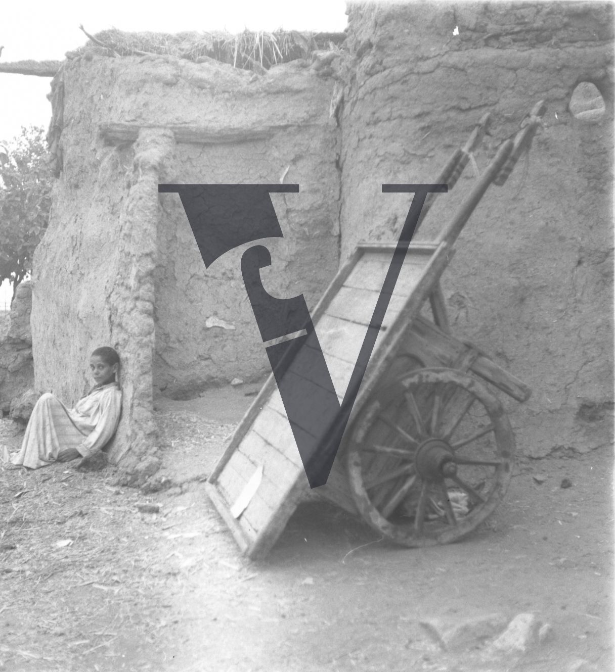 Harrania, Egypt, boy sits near handcart.