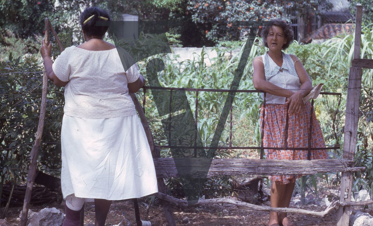 Jamaica, Two women speak over the fence.