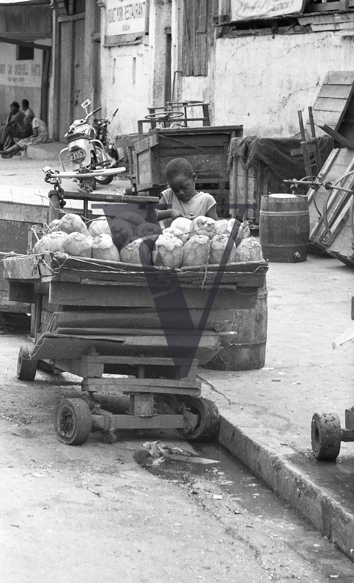 Jamaica, Boy attends to fruit cart on street.