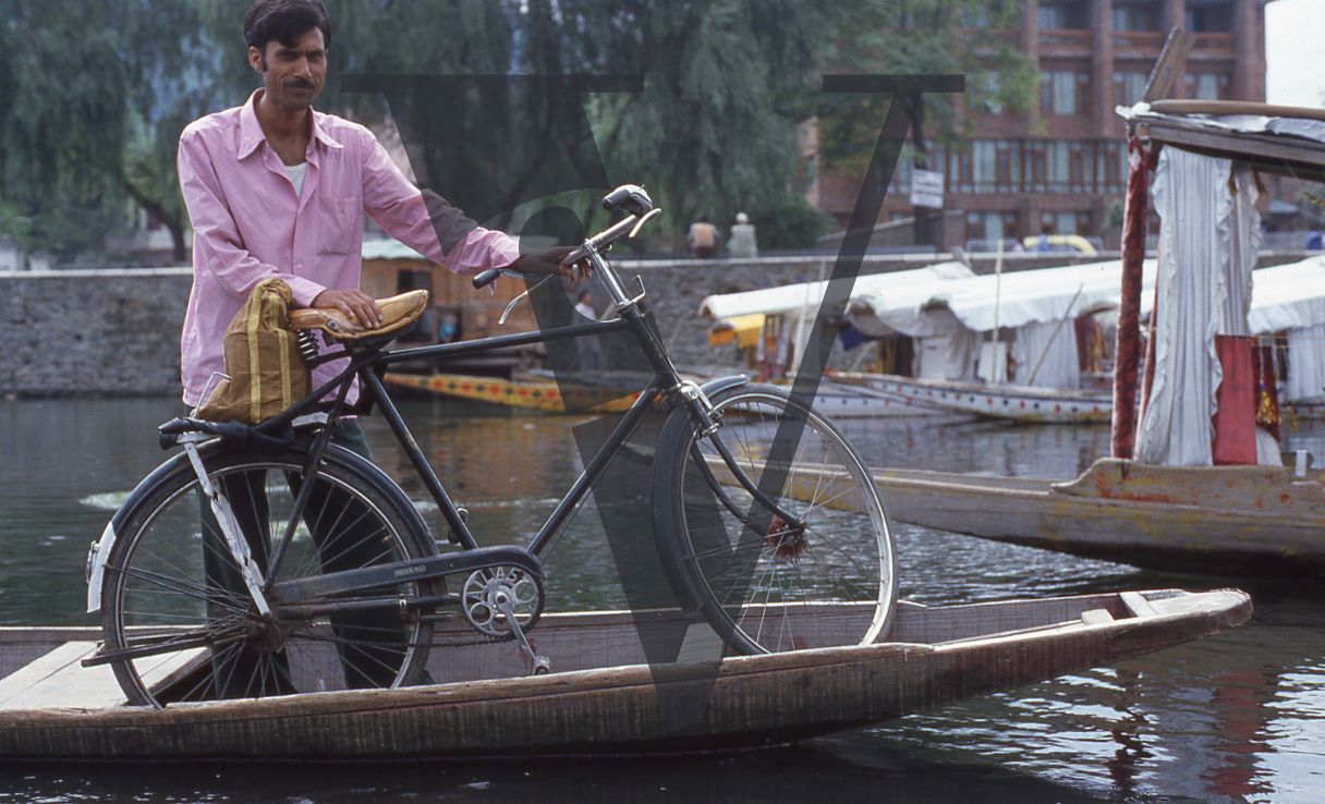 Kashmir, Man with bicycle on boat.