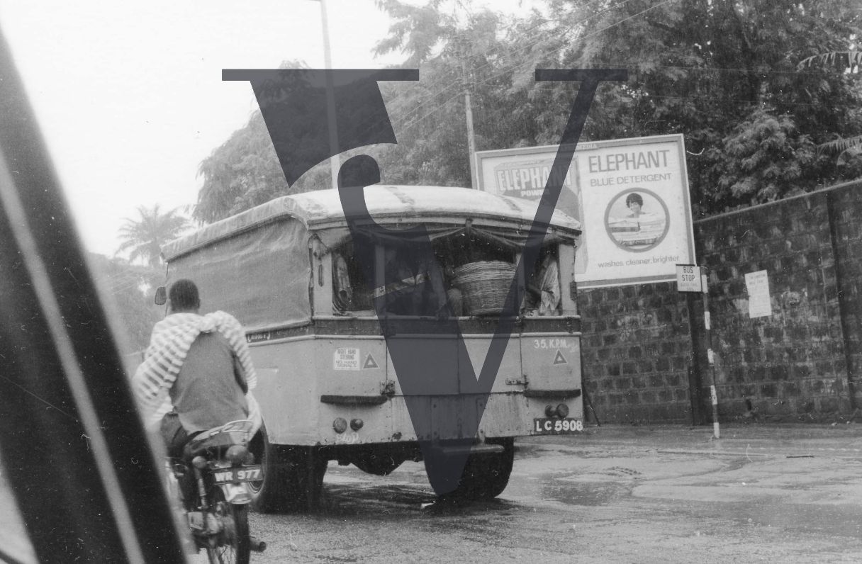Nigeria, Lagos, rainy day, van drives past a Elephant Blue Detergent billboard.