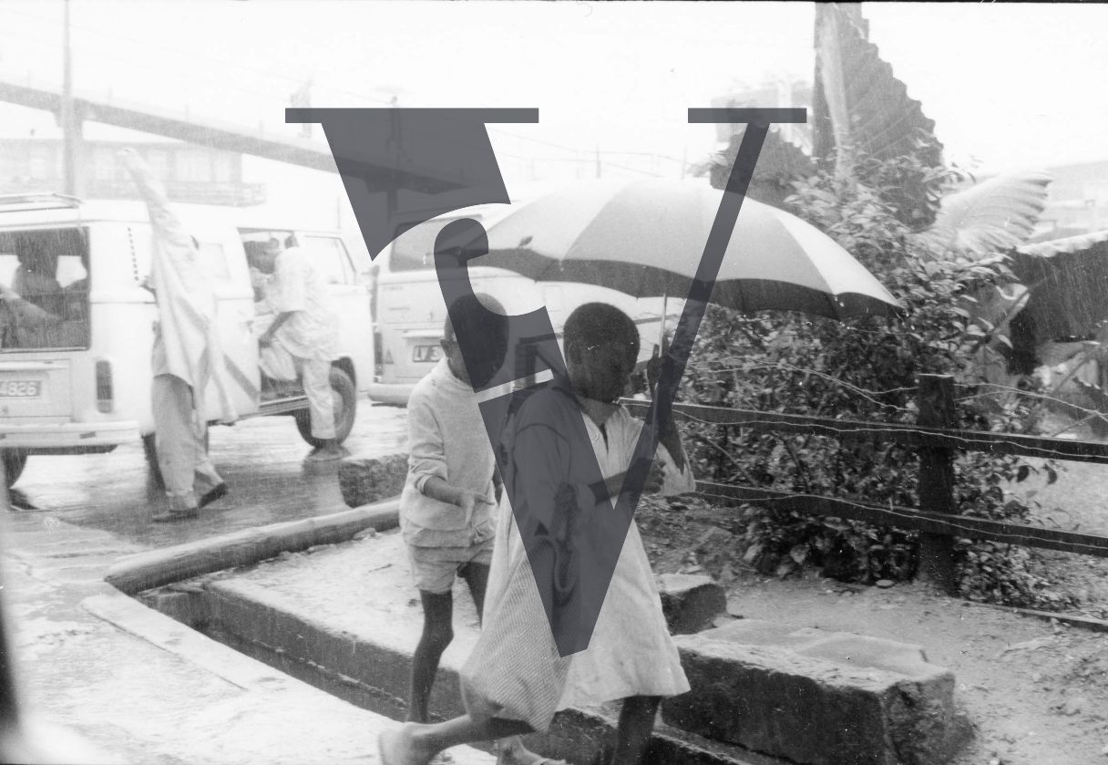 Nigeria, Lagos, rainy day, children with umbrella.