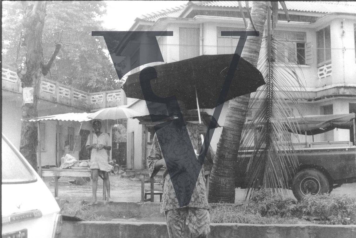 Nigeria, Lagos, rainy day, women laughing at camera, umbrella.