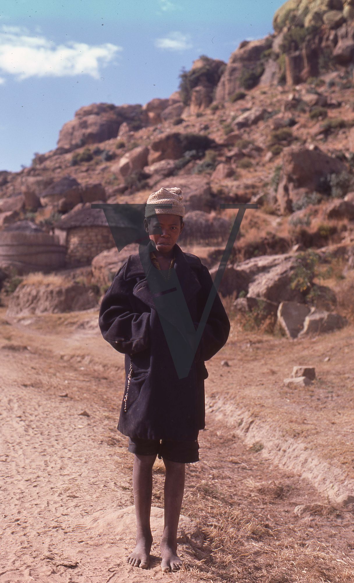 Lesotho, Handspun mohair farming community, boy in black coat and hat, portrait.
