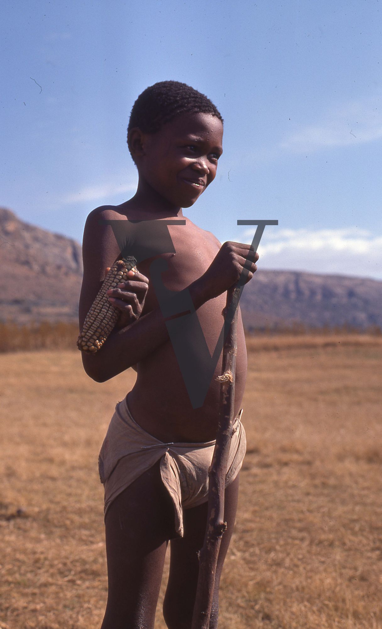 Lesotho, Handspun mohair farming community, boy with corn, smiling, portrait.