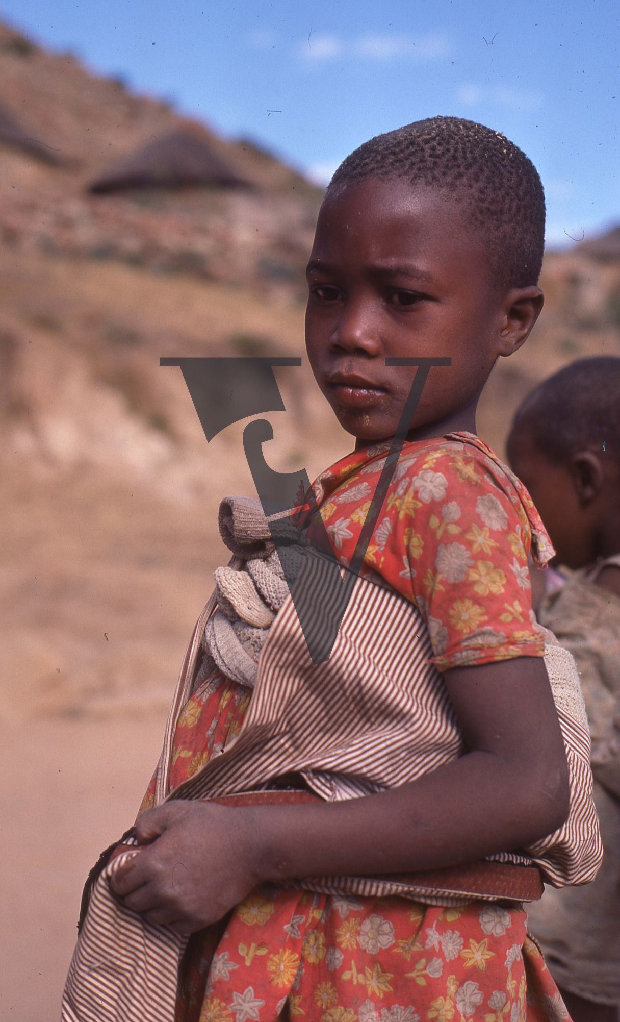 Lesotho, Handspun mohair farming community, girl looks on, portrait.