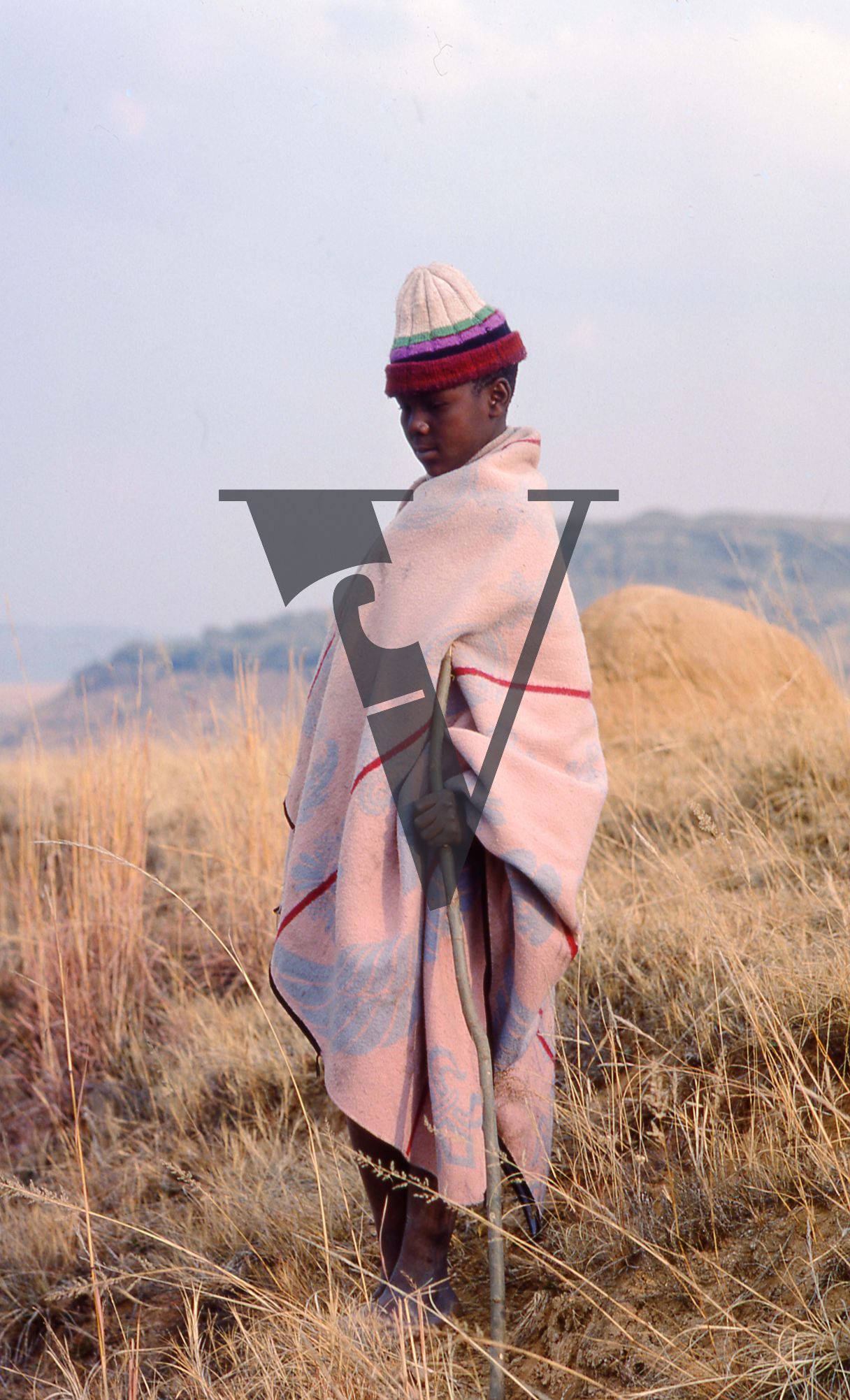 Lesotho, boy in blanket and striped hat, portrait.