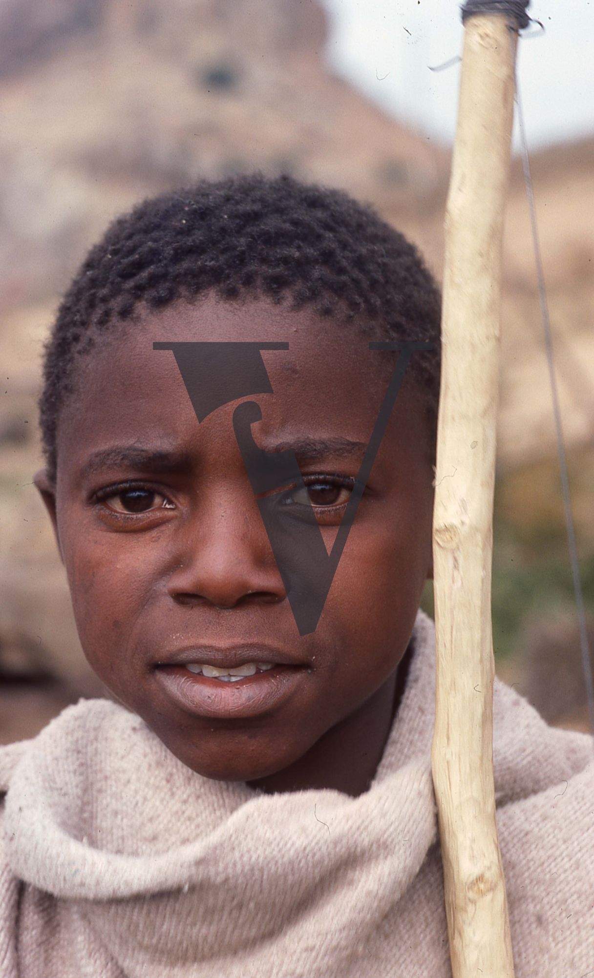 Lesotho, close up, boy with stick instrument, portrait.
