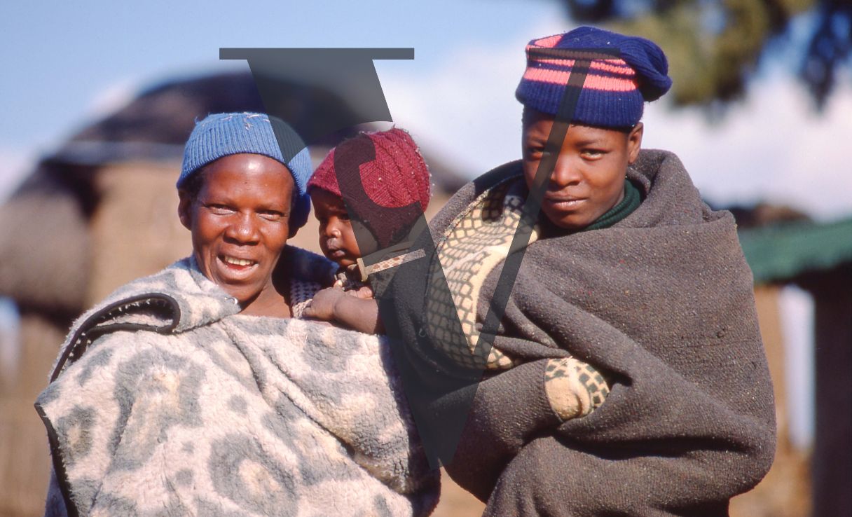 Lesotho, woman with baby and child, blankets, portrait.