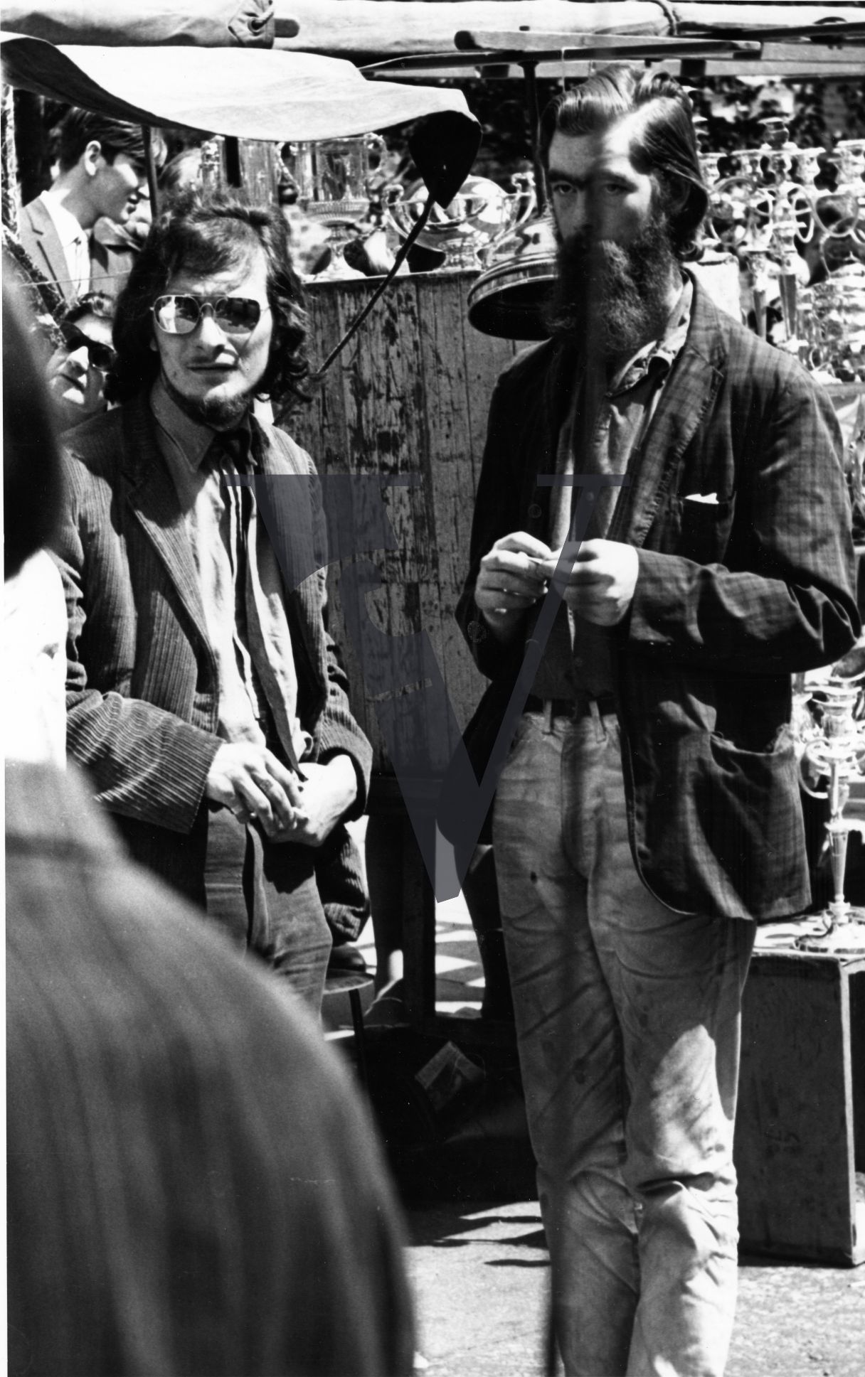 London, Sixties, bohemian men, standing on Portobello Road market.
