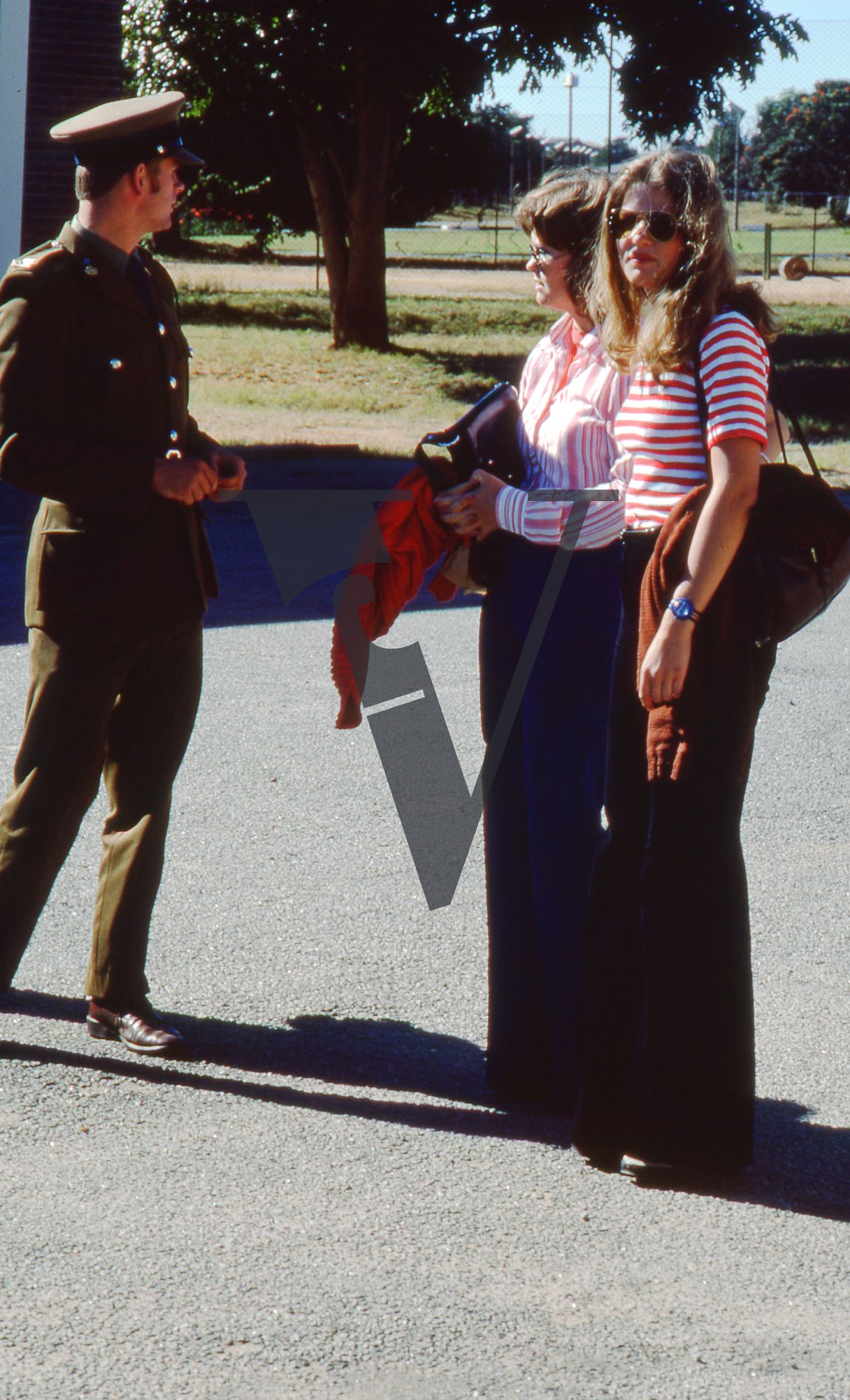 Rhodesia, Rhodesian Light Infantry passing out ceremony, British South Africa Policeman (BSAP) with two women, full shot.