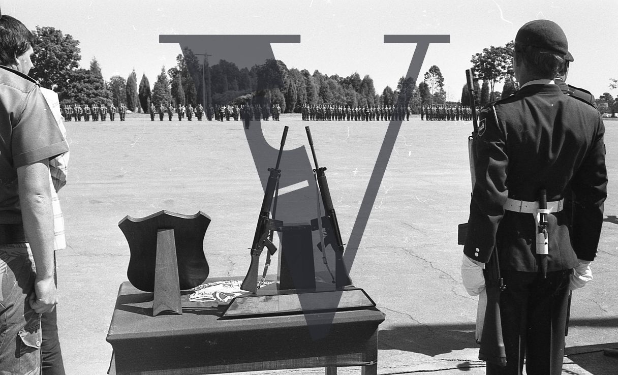 Rhodesia, Rhodesian Light Infantry, passing out ceremony, soldiers rifles on display, military display plaque, reverse angle shot.