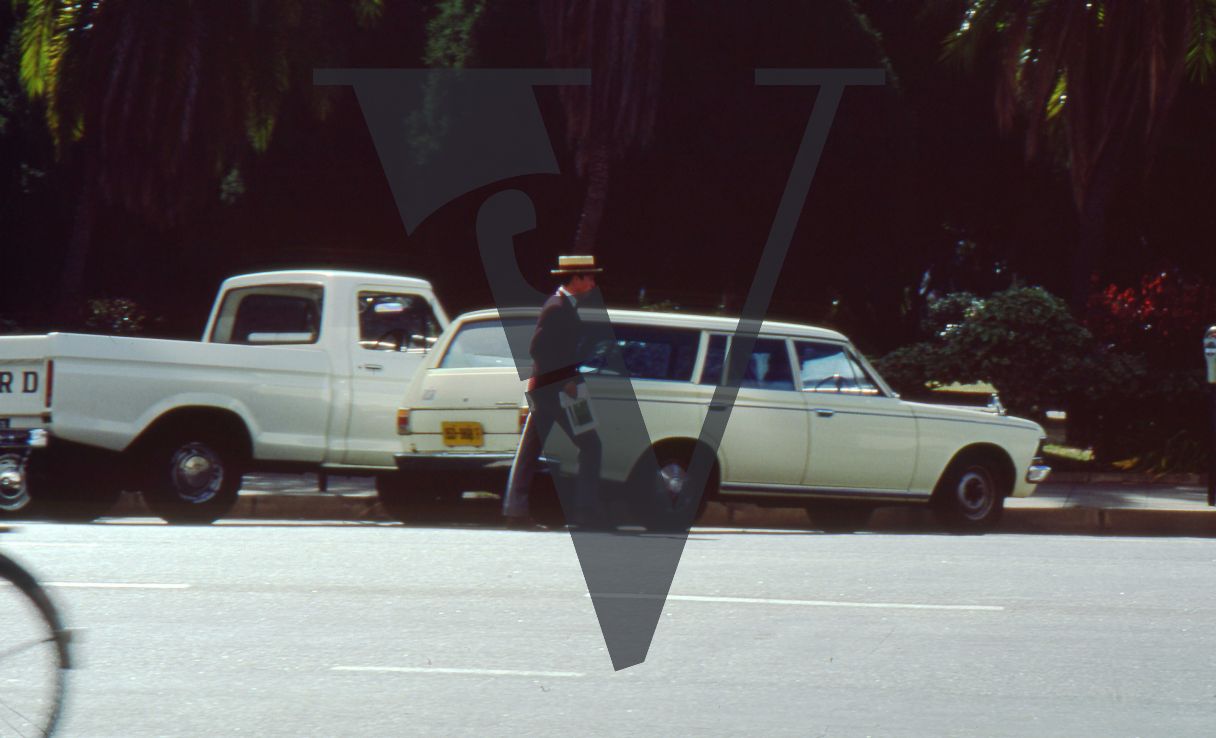 Rhodesia, Salisbury, street scene, parked cars, man in straw boater hat, long shot.