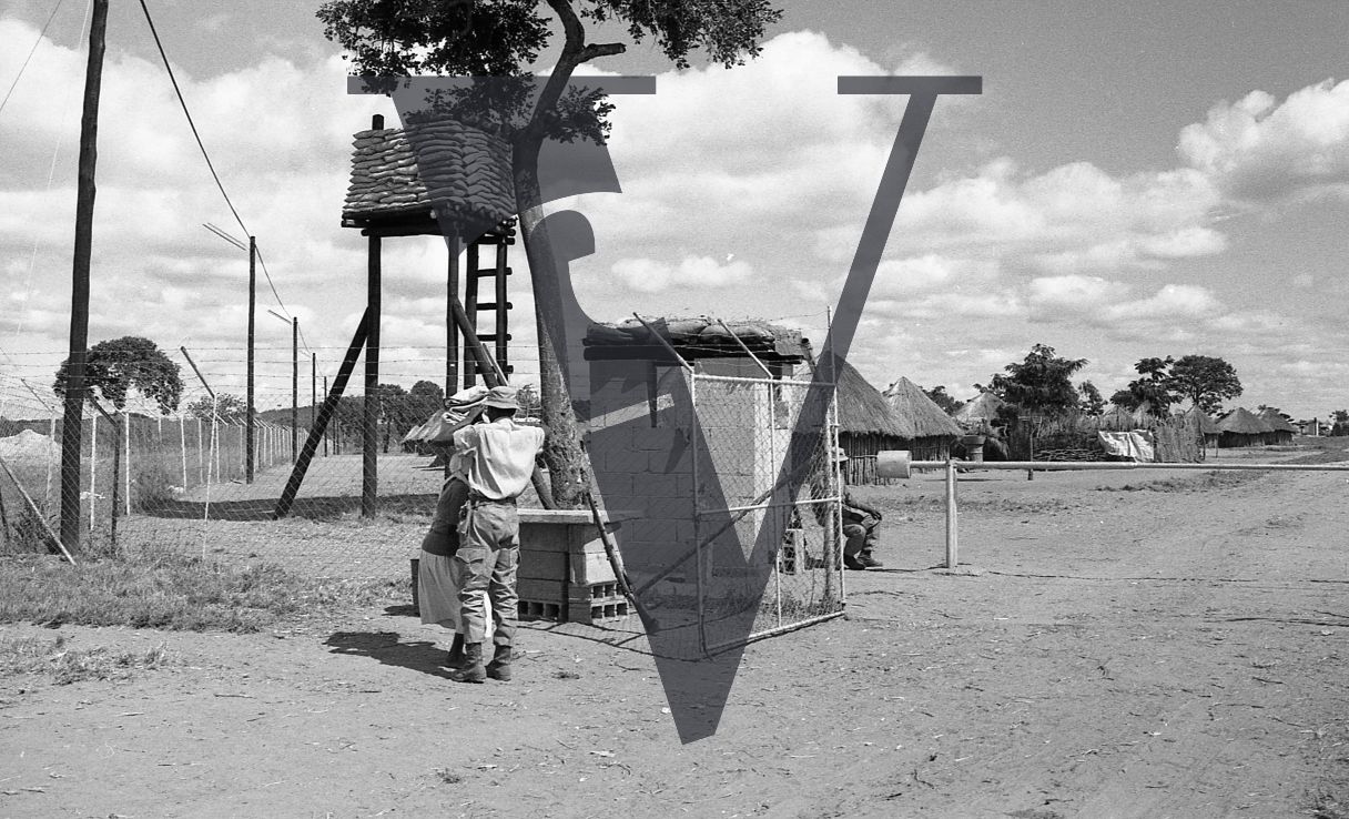 Rhodesia, “protected village”, fence, gun tower, guards, woman, wide shot.