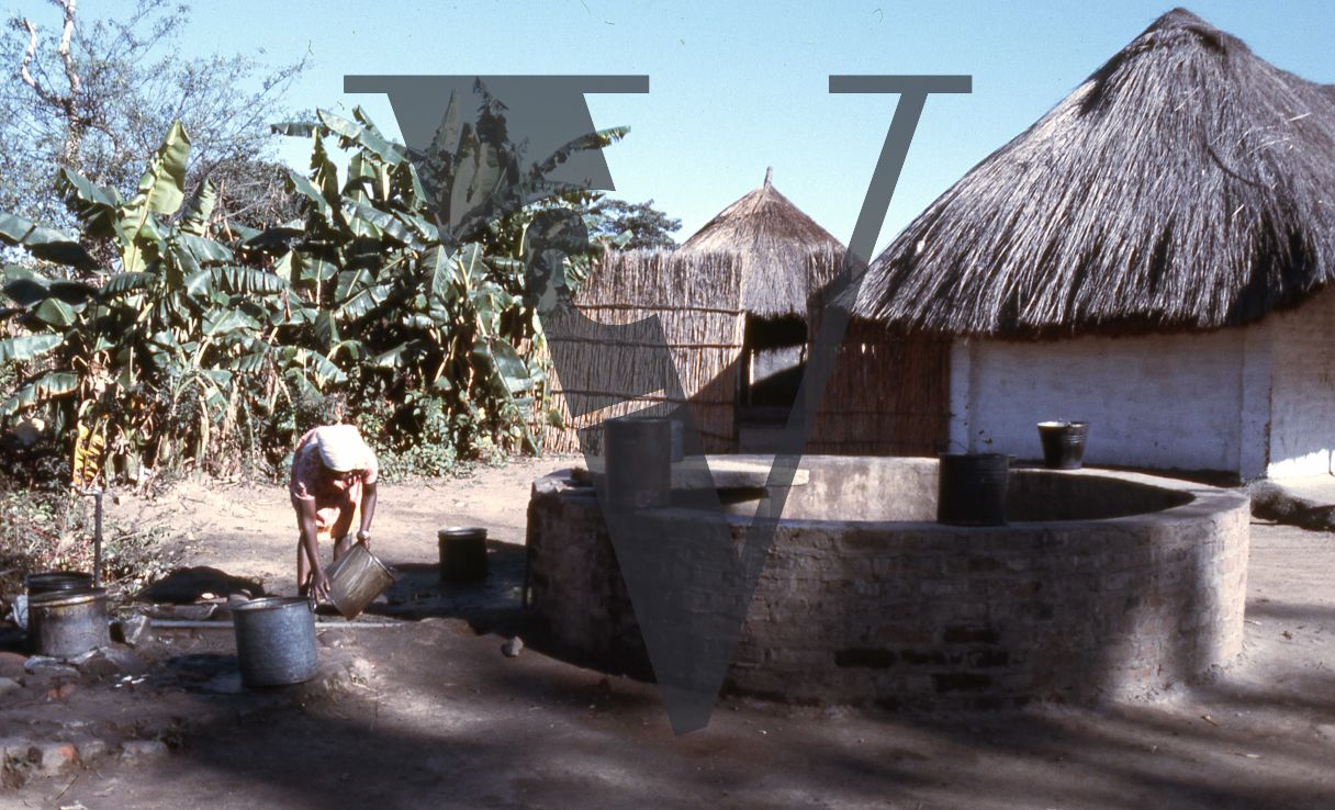 Rhodesia, tobacco farm, worker, well, rondavels.