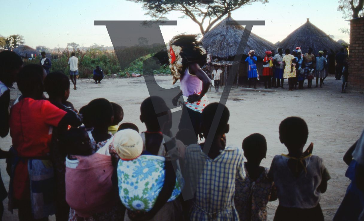 Rhodesia, farm, rondavels, crowd, dance, ceremonial dress, mask.