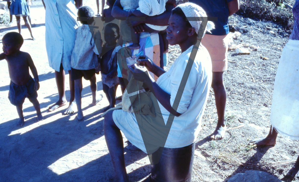 Rhodesia, tobacco farm, woman knitting, seated, women with children.