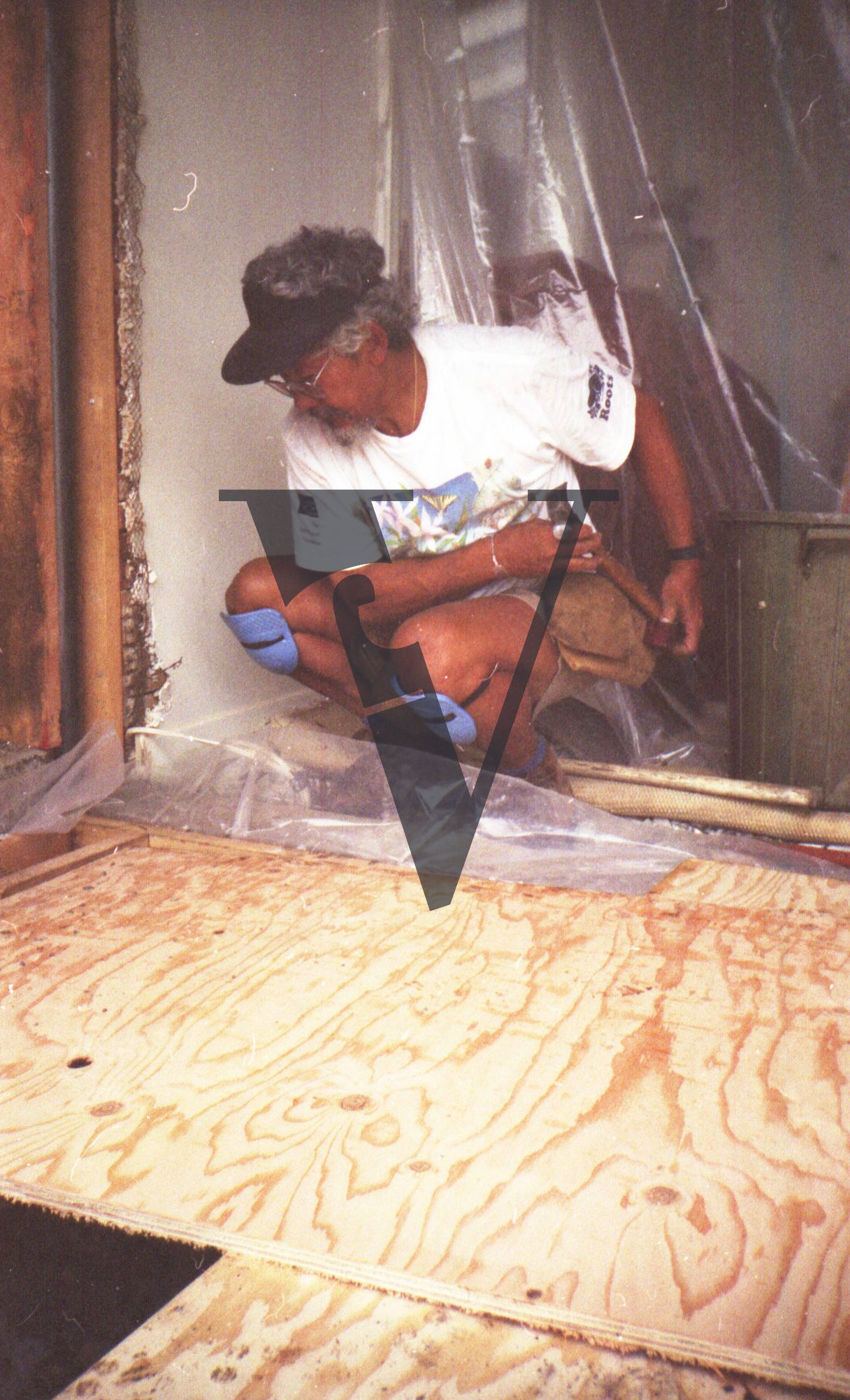 David Suzuki housebuilding in Vancouver, wooden materials, on knees.