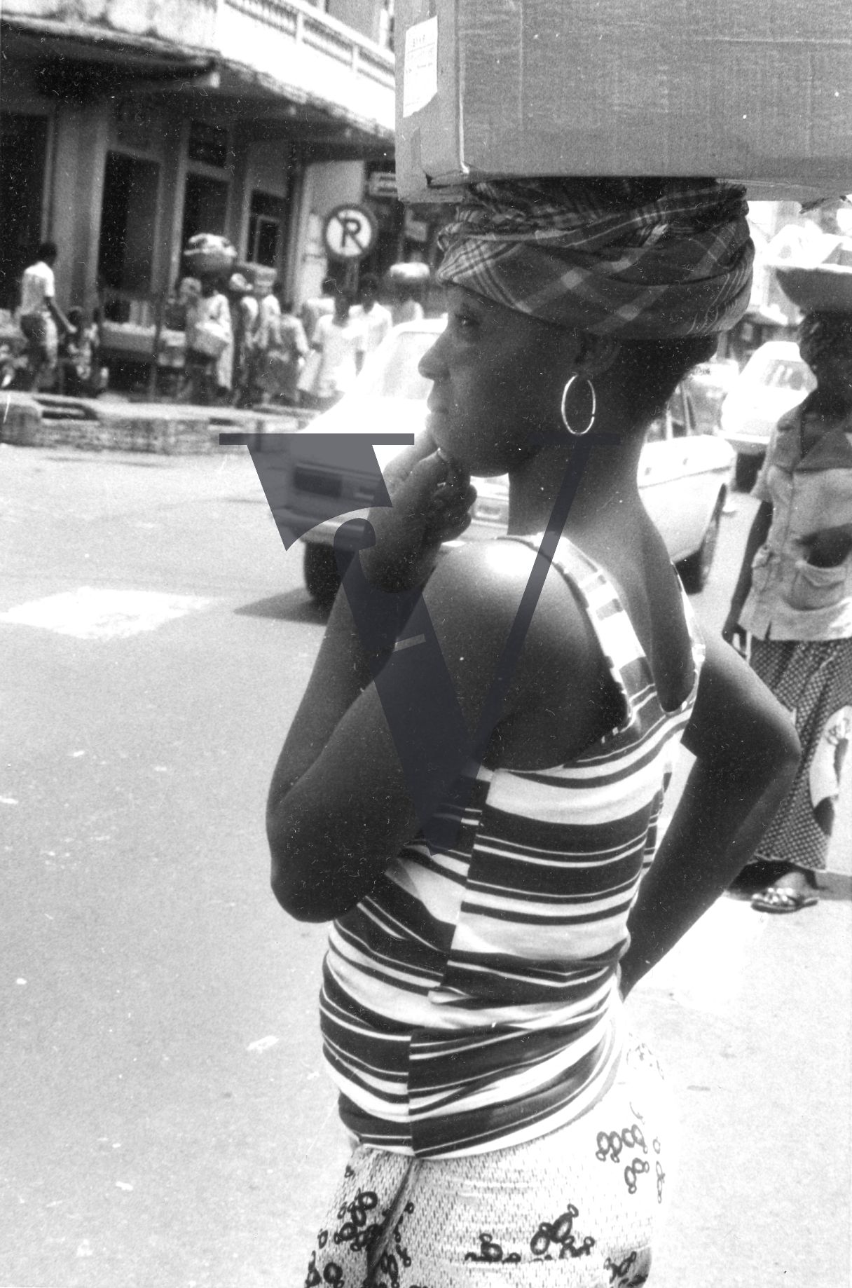 Sierra Leone, streets, woman carrying basket on head.
