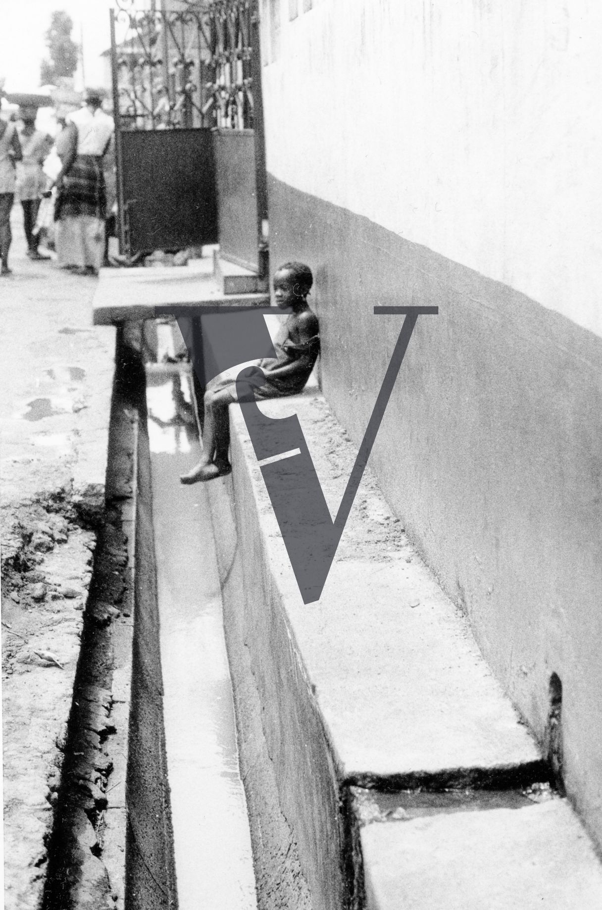 Sierra Leone, streets, small child alone on wall.