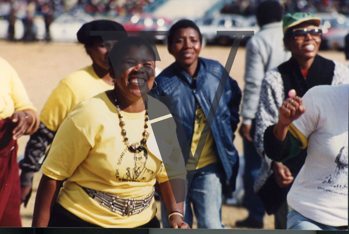 Woman smiling and dancing in Soweto Civic Health Team T-shirt.